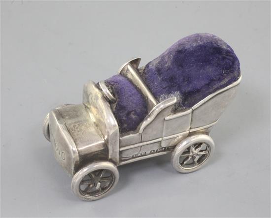 A rare Edwardian novelty silver pin cushion modelled as a vintage car, with rotating wheels, by Levi and Salaman, 54mm.